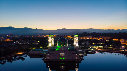 Aerial Drone image of beautiful mosque and the most famous tourist spot Likas Mosque(Masjid Bandaraya Likas), Kota Kinabalu, Sabah, Malaysia. during Twilight Sunrise and low light condition