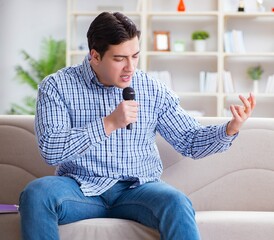 Funny man singing songs in karaoke at home