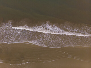 Aerial drone image view of ocean waves crashing on beach