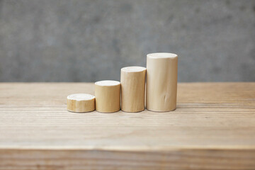 Thin and short barkless wooden log blocks on wooden table. Barkless cedar log set lined up closely together in order of height on wooden background. 