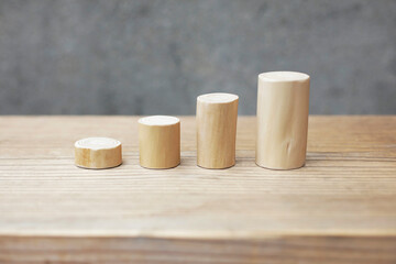 Thin and short barkless wooden log blocks on wooden table. Barkless cedar log set lined up individually in order of height on wooden background. 
