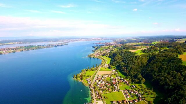 Panning aerial view of a town by a lake under blue sky in Zurich, Switzerland