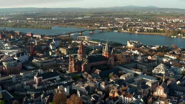 Flying closer to the Cathedral church of Mainz with drone shots on a warm spring day showing the blue river in the back