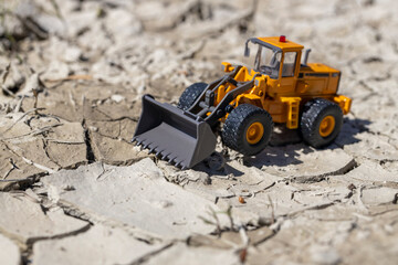 渇水でひび割れた地面とホイールローダー