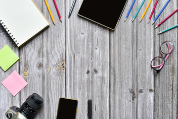 Still life, business or traveler memo concept, Top view image of open notebook with vintage camera coffee colorful pencil and tablet with blank pages on old brown wooden background, for adding text