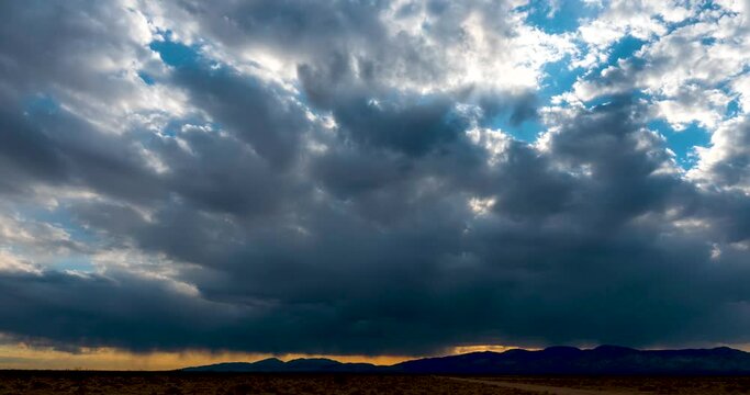 Rain storm sweeps across the parched landscape of the Mojave Desert - time lapse of the dramatic cloudburst and sunset