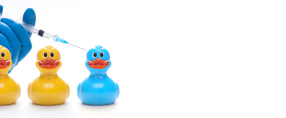Medical syringe with a needle for vaccination on a duck toy.