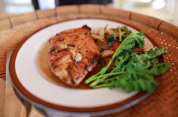Local Thai food  in The wood tray , Chicken steak by Thai Style. Top view food photography. Chicken steak and vegetable boiled setting on the  Thailand local wood tray in  the  farm house.