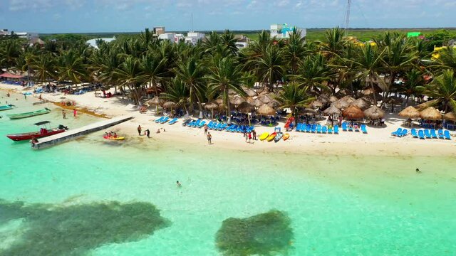 Drone shot of people on the resort beach at Mahahual Mexico. Beautiful clear ocean water.