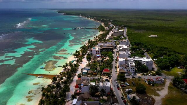 Cinematic drone shot of the coastal resort town of Mahahual Mexico, beautiful clear ocean water.