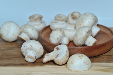 Mushrooms on a wooden chopping board on a white background