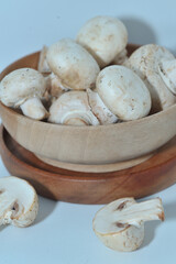 Mushrooms on a wooden chopping board on a white background