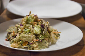 white plates holding green chopped salad with avocado dressing