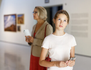 Portrait of tweenage girl looking at exposition in historical museum