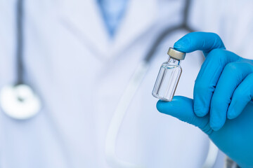 Coronavirus Vaccine concept in hand of doctor vaccine jar. Vaccine Concept of fight against...