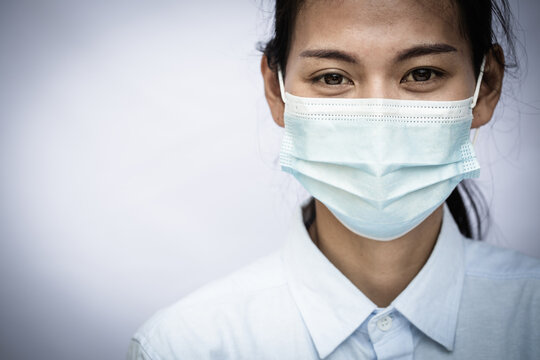 Woman wearing mask, covering face to prevent contagious disease, COVID 19, Coronavirus, Portrait of a woman in a medical mask. Young woman patient, copy space