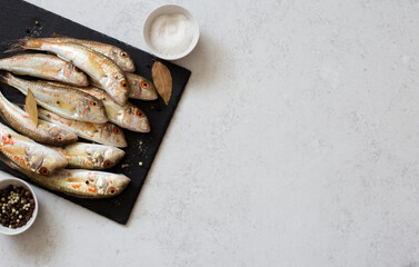 Raw uncooked  red mullets on gray background