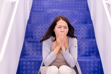 Tourist woman suffering from sea sickness and feeling vomiting while on cruise