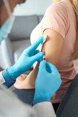 Close up patient hand and doctor hand putting flu vaccination injection on arm