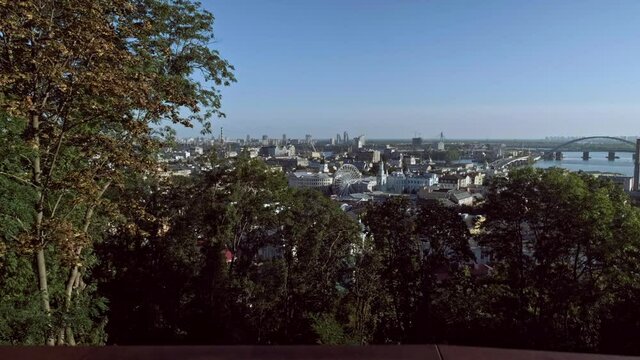 Camera rises from behind fence to reveal Podil district of Kiev on a beautiful autumn morning