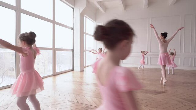 Girls dancers in ballet school learns to dance. Little Ballerinas in training in pink dancing suit. Children's ballet school. School of ballet.
