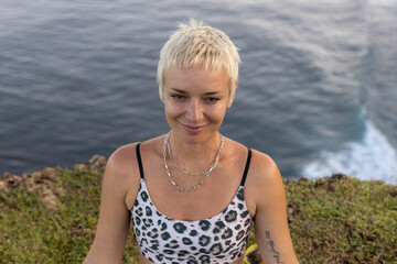 Portrait of woman with short blond hair. Practicing meditation and pranayama breathing exercise....