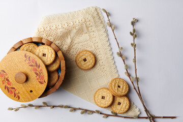 on a white background willow twigs and a cup with round cookies on a napkin