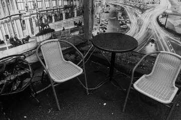 Wicker chairs and a table against the background of photo banners depicting the city.