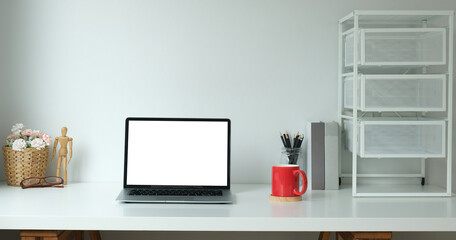 Fototapeta premium Modern workspace with computer with blank screen and equipment on white table.Blank screen for your information.