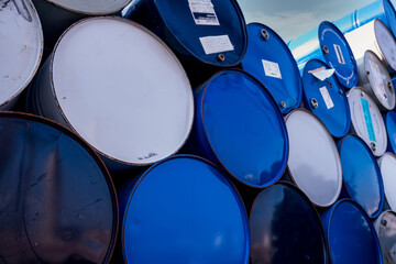 Closeup old chemical barrels. Blue and white oil drum. Steel oil tank. Toxic waste warehouse....