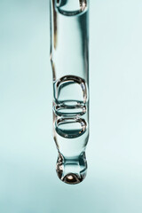 A drop of cosmetic oil falls from the pipette