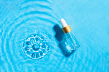 Cosmetic spa medical skin care,  serum bottle , micellar toner or emulsion on blue water texture...