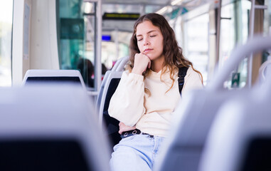 Portrait of a tired girl with her eyes closed, riding home on public transport