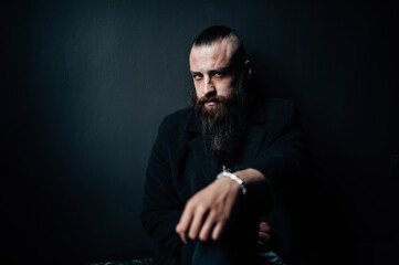 A man with a long beard looks into the camera