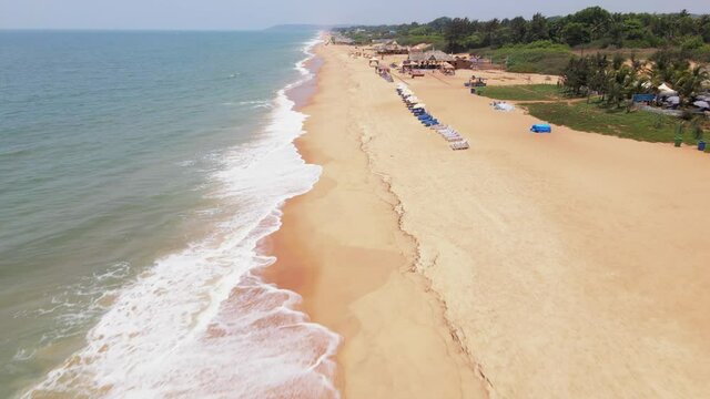 goa Sinquerim Beach drone bird's eye view drone coming down towards  tilt-up flying close to the beach on waves