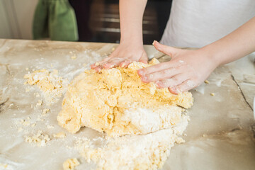 Child's hands kneading dough at home in the kitchen. Cooking at home