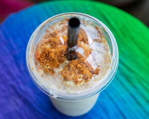 Iced blended caramel coffee topped with crushed caramel biscoff in plastic glass. Hot season...
