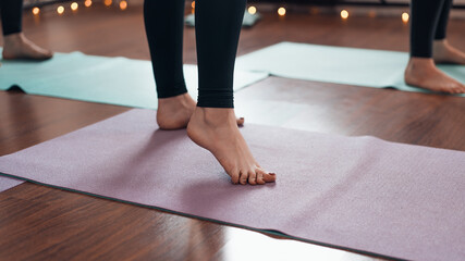 Woman standing on a sports mat indoors. Close-up of female legs, selective focus. Fitness, yoga,...