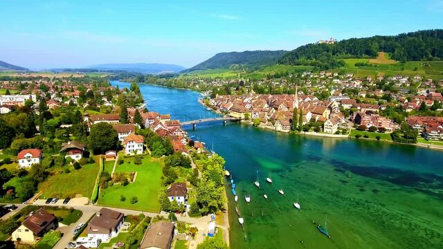 Drone panoramic view of a beautiful town and river in Zurich, Switzerland, with some cars passing by on a bridge