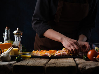 Chef prepares chicken roll for cooking meat dishes. Culinary recipes. Against the background of ingredients.Menu or restaurant business