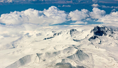 View through clouds at mountain peaks. Fantastic terrific natural landscape. Use for background, backdrop or design element in natural concept