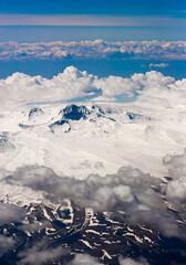 View through clouds at mountain peaks. Fantastic terrific natural landscape. Use for background, backdrop or design element in natural concept