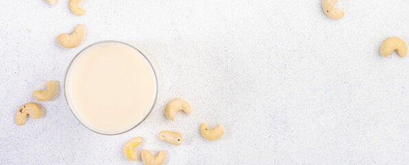 Vegan Cashew nut milk on white background. Non dairy alternative vegan drink. Healthy vegetarian food and beverage. Copy space, top view