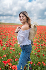Obraz na płótnie Canvas Caucasian model enjoy life at poppy field, sunny day