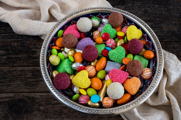 Bowl of candies and chocolate on the wooden table