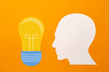 Papercut head and light bulb on paper background