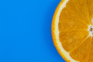 Yellow juicy orange on a blue background. Background on the theme of fruits, citrus fruits.