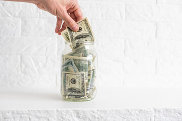 One hundred dollar bills in a glass jar