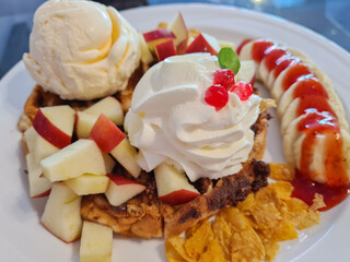 Whipped cream and waffles topped with fruit