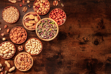 Fototapeta na wymiar Nuts with copy space. Many different nuts in wooden bowls, shot from the top
